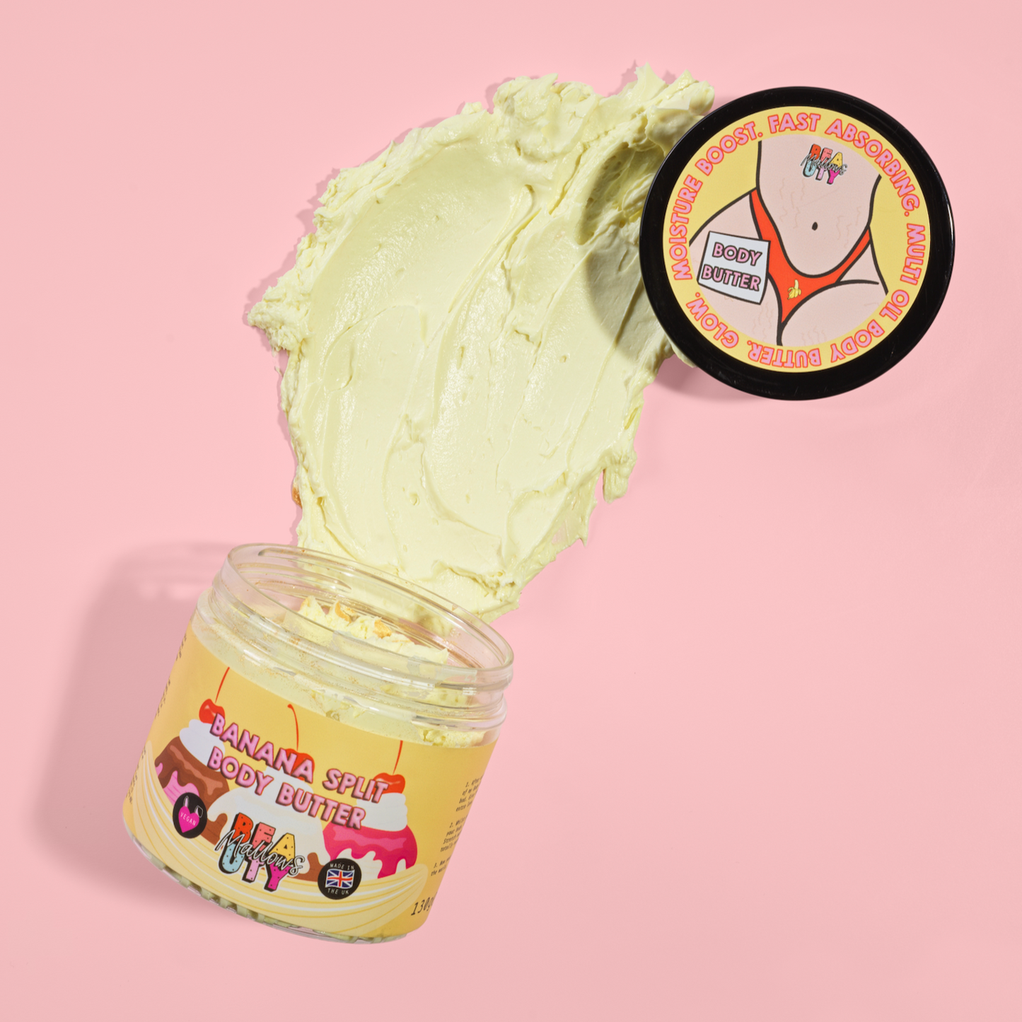 Jar of banana split body butter with a scoop on a pink background