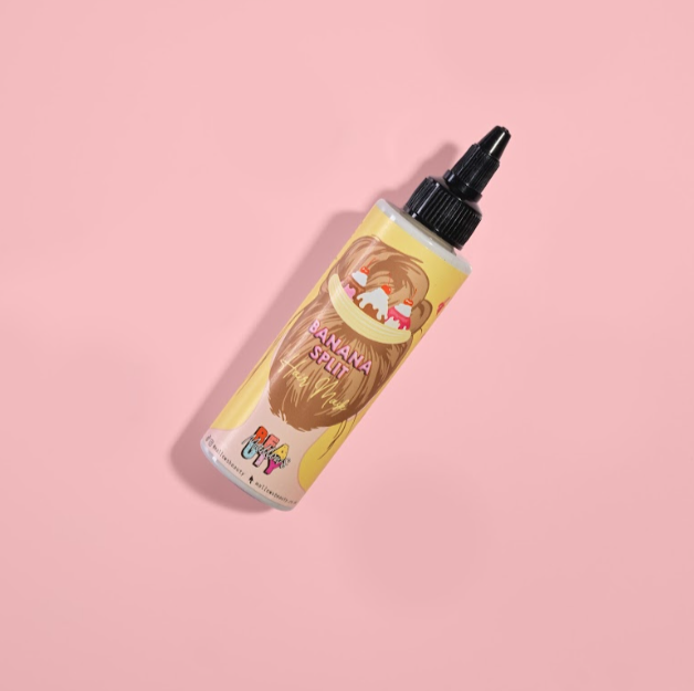 Banana split hair mask in a bottle on a pink background